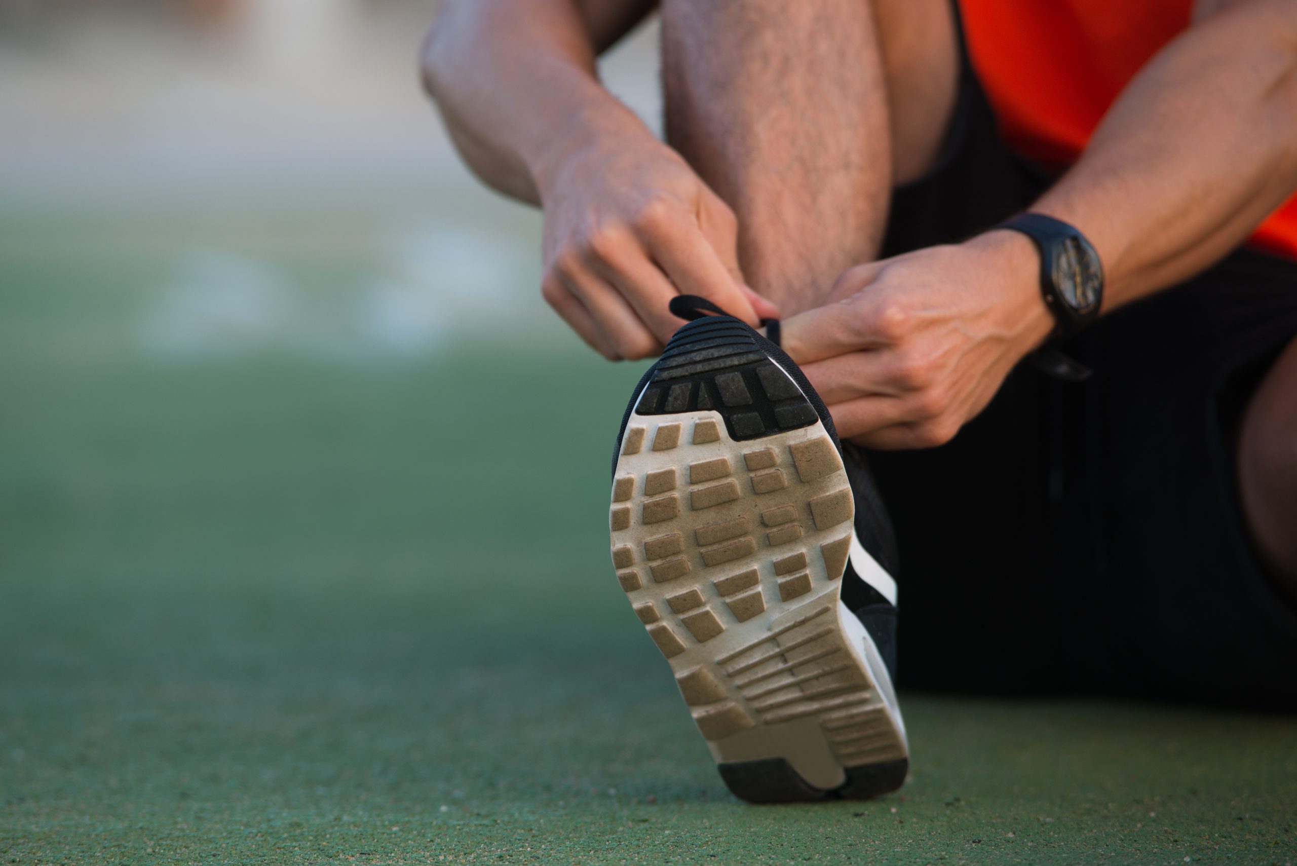 Close-up of male hands tying up sport shoes