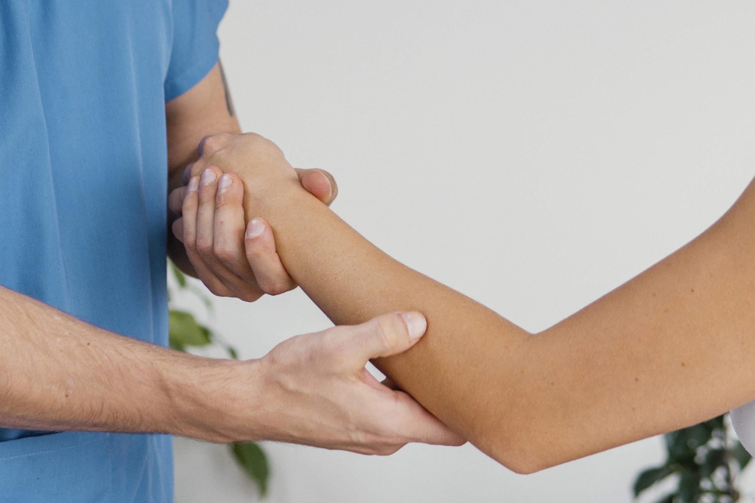side-view-male-osteopathic-therapist-checking-female-patient-s-elbow-movement